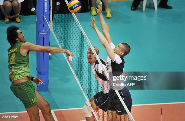 Finland's Mikko Esko watches as Jukka Lehtonen jumps to block Brazil's Rodrigo Santana's spike during the FIVB World League volleyball match between...