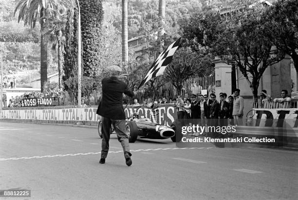 The Monaco Grand Prix; Monte Carlo, May 22, 1966. With an athletic flourish, Louis Chiron presents the checkered flag to Jackie Stewart's winning...