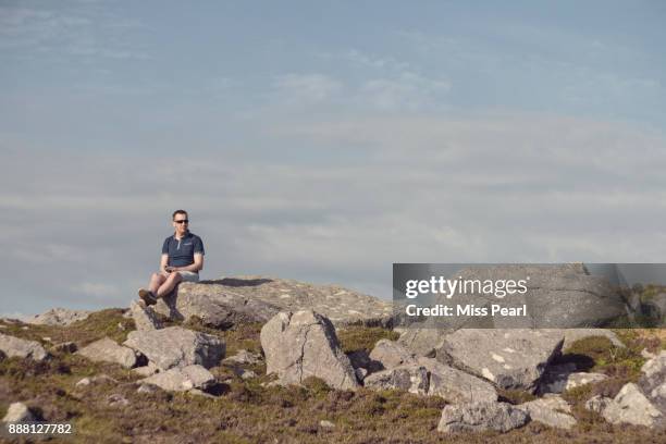 man enjoys view from rocks on west coast of ireland - dingle bay stock pictures, royalty-free photos & images