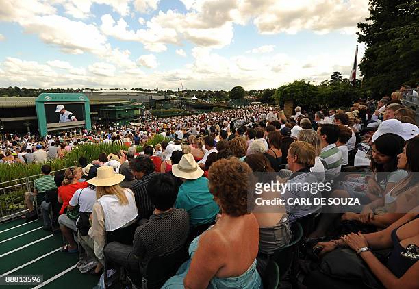 Tennis fans gather on 'Murray Mount' to watch a television screen showing the match between Britain's Andy Murray and Andy Roddick of the US in a...