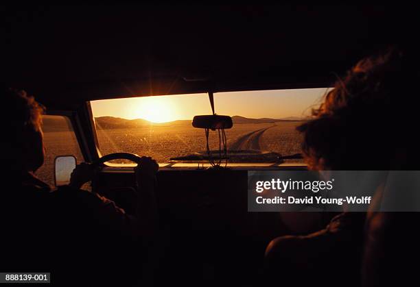 couple driving down valley at sunset, kaokoveld, namibia - car interior sunset stockfoto's en -beelden