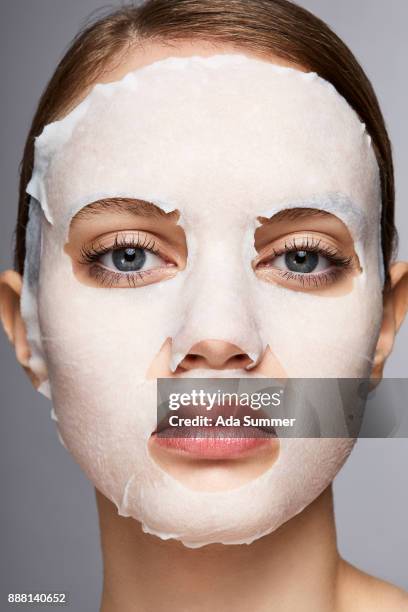 woman wearing a moisturizing sheet mask - peel off mask stock-fotos und bilder