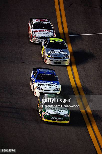 Clint Bowyer, driver of the Holiday Inn Chevrolet, leads Dale Earnhardt Jr, driver of the Fastenal Chevrolet, Brad Keselowski, driver of the Klondike...