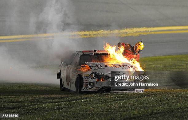 Kertus Davis, driver of the NuTone Heating & Cooling Products Chevrolet, climbs out of his car after it catches fire prior to a crash on track during...