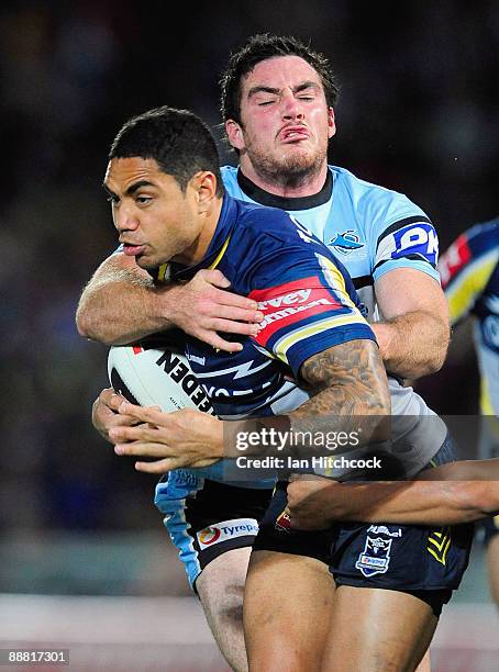 Willie Tonga of the Cowboys is tackled by Grant Millington of the Sharks during the round 17 NRL match between the North Queensland Cowboys and the...