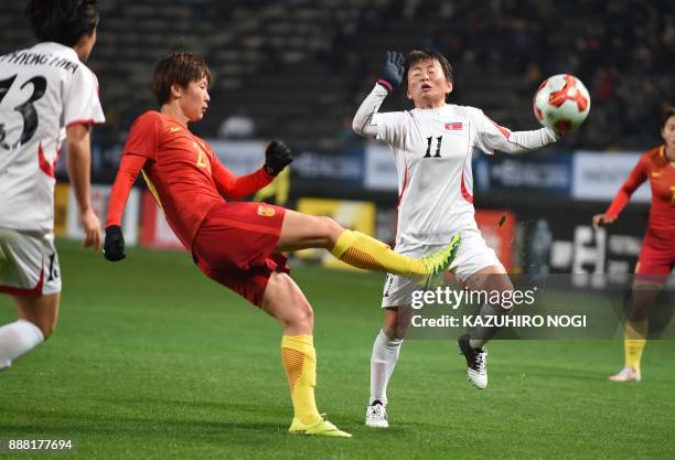 North Korea's Sung Hyang Sun and China's midfielder Zhang Rui fight for the ball during their women's football match between North Korea and China at...