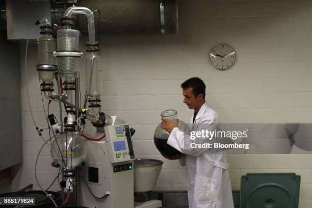 Lab technician handles a vat of CBD oil by a vacuum rotary evaporator inside the laboratory facility at KannaSwiss GmbH in Koelliken, Switzerland, on...