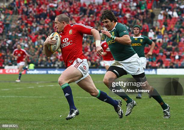 Shane Williams of the British & Irish Lions beats Jaque Fourie of South Africa on his way to scoring his second try during the Third Test Match...