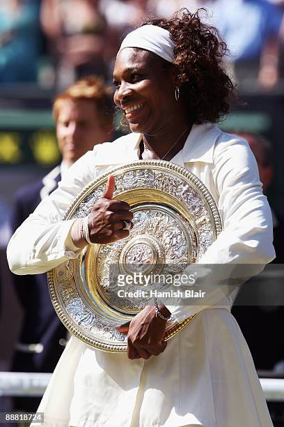 Serena Williams of USA celebrates with the Championship trophy after the women's singles final match against Venus Williams of USA on Day Twelve of...