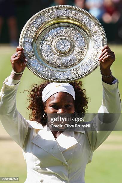 Serena Williams of USA celebrates with the Championship trophy after the women's singles final match against Venus Williams of USA on Day Twelve of...