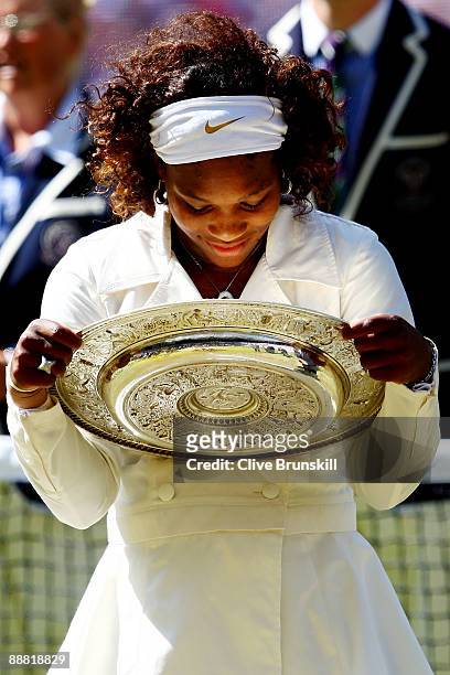 Serena Williams of USA celebrates with the Championship trophy after the women's singles final match against Venus Williams of USA on Day Twelve of...