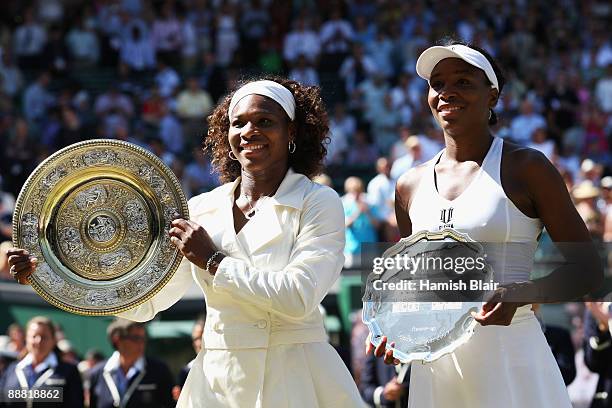 Victorious Serena Williams of USA stands alongside sister Venus Williams of USA after the women's singles final match on Day Twelve of the Wimbledon...