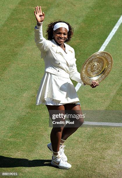 Serena Williams of USA celebrates with the Championship trophy after the women's singles final match against Venus Williams of USA on Day Twelve of...