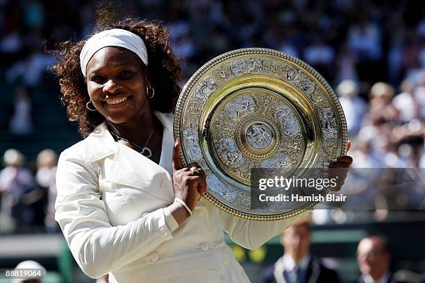 Serena Williams of USA celebrates with the Championship trophy after the women's singles final match against Venus Williams of USA on Day Twelve of...