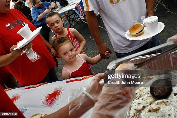 Joeli Casados, age 3, and her sister Kayla, age 6, are served lunch at an Independence Day picnic on July 4, 2009 held by the Salvation Army in...