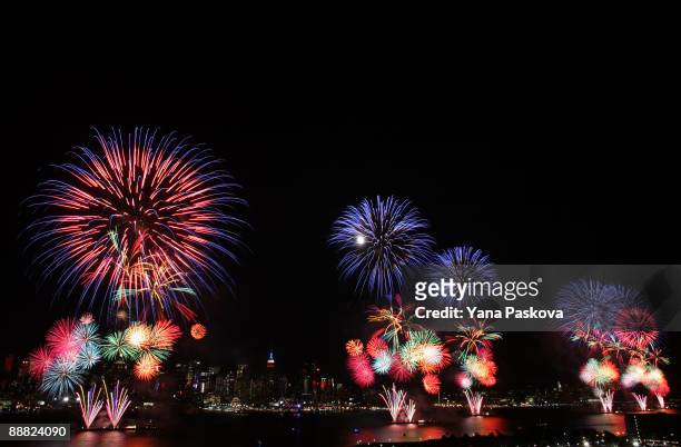 The New York City skyline is seen in the distance as fireworks explode over the Hudson River during the Macy's fireworks display July 4, 2009 in...
