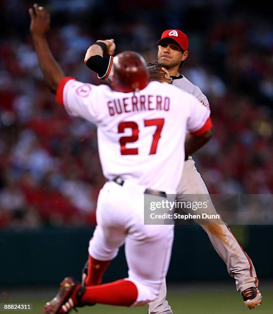 Second baseman Brian Roberts of the Baltimore Orioles throws to first to complete a double play after forcing out Vladimir Guerrero of the Los...