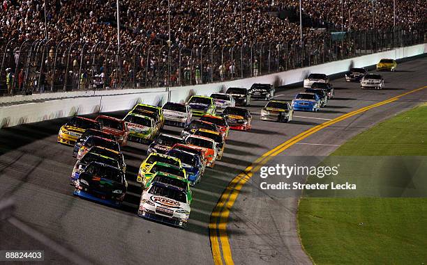 Denny Hamlin, driver of the FedEx Office Toyota, and Tony Stewart, driver of the Burger King Chevrolet, lead a double file restart in the closing...