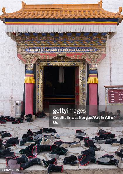 Tibetan monks boots in front of the entrance of a temple in Labrang ...