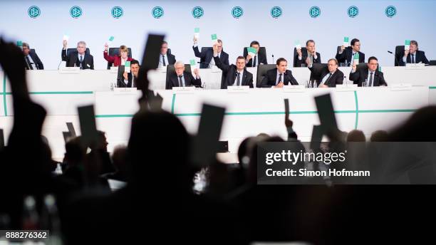 Members of the DFB Presidium show their vote cards during the Extraordinary DFB Bundestag at Messe Frankfurt on December 8, 2017 in Frankfurt am...