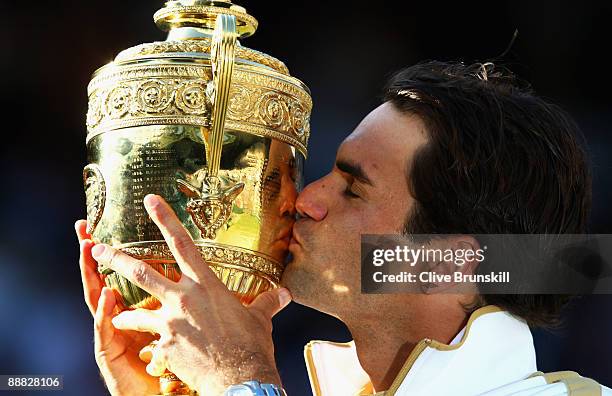 Roger Federer of Switzerland kisses the trophy after victory during the men's singles final match against Andy Roddick of USA on Day Thirteen of the...