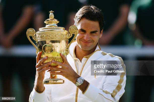 Roger Federer of Switzerland celebrates victory with the trophy after the men's singles final match against Andy Roddick of USA on Day Thirteen of...