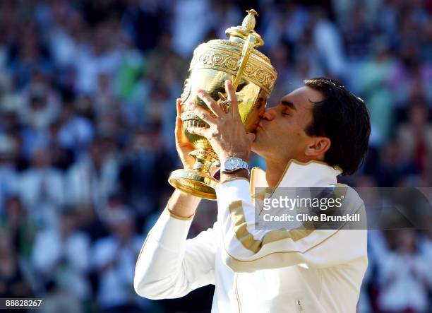 Roger Federer of Switzerland kisses the trophy after victory during the men's singles final match against Andy Roddick of USA on Day Thirteen of the...