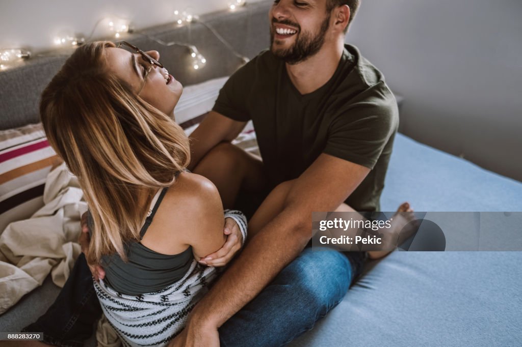 Happy Couple Laughing In Bed