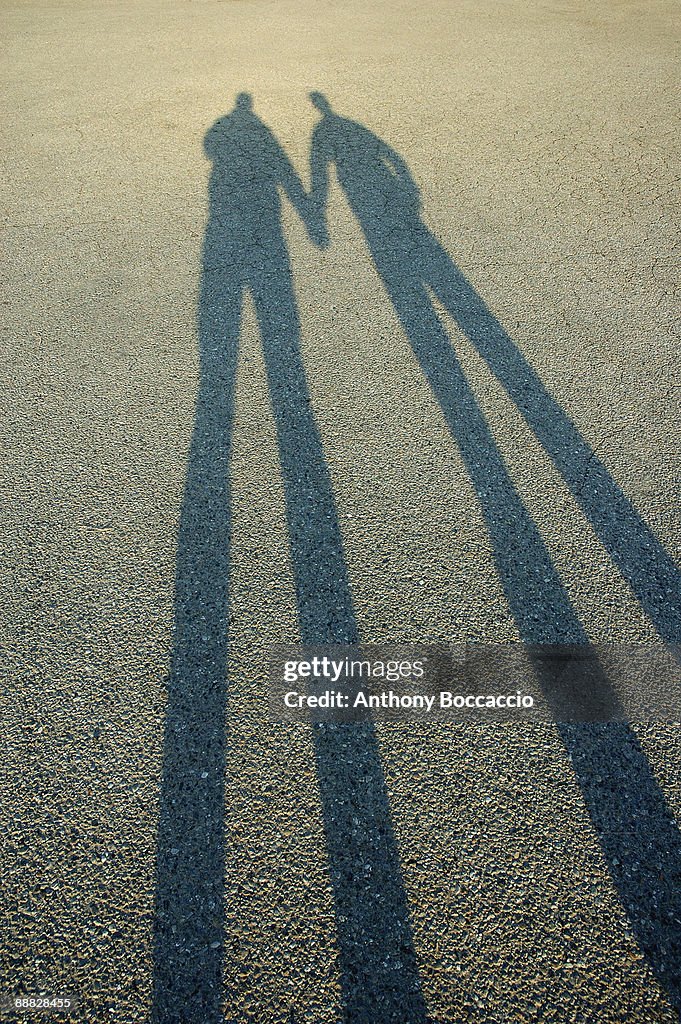 Shadow of two people holding hands