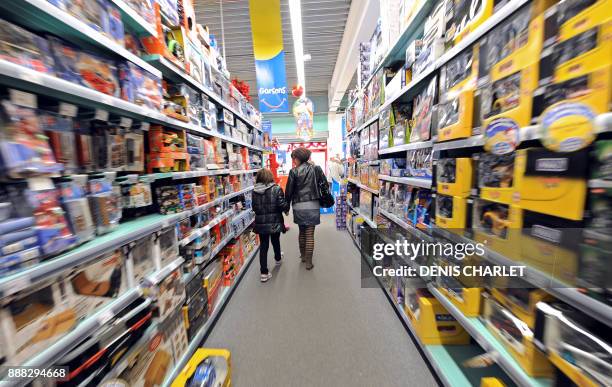 Mother and her daughter walk past the shelves of La Grande Recre toys departement store in the French northern city of Bruay-la-Buissiere on November...