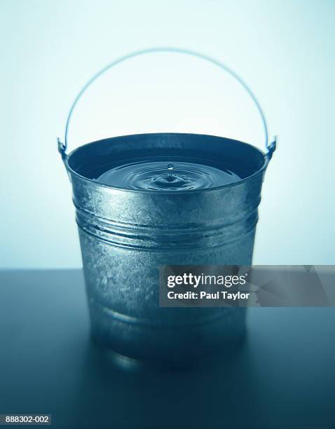 droplet creating ripple in bucket of water (toned b&w) - bucket fotografías e imágenes de stock