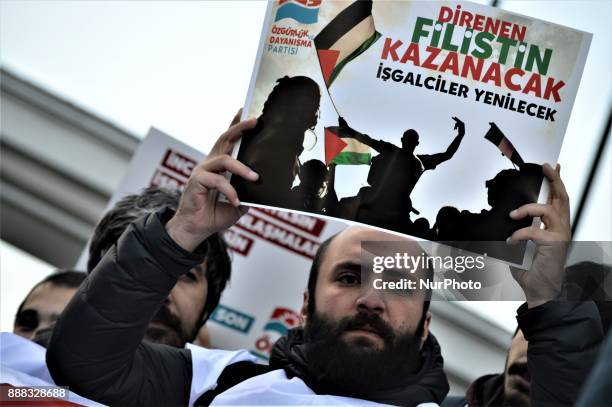 Photo taken in Ankara, Turkey on December 8, 2017 shows a protester holding a placard as leftists take part in a protest near the U.S. Embassy...