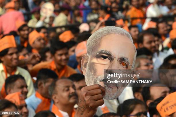 Supporter of Bhartiya Janta Party hold a cut out of Indian Prime Minister Narendra Modi during a rally at Kalol, some 30 kms from Ahmedabad on...