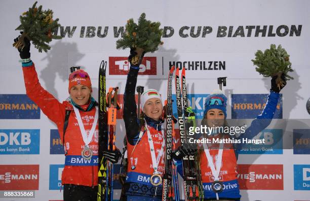 Anastasiya Kuzmina of Slovakia celebrates second place, Darya Domracheva of Belarus celebrates first place and Dorothea Wierer of Italy celebrates...