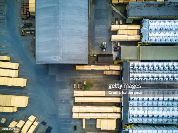 stacked planks around buildings in sawmill - depósito de madeiras imagens e fotografias de stock