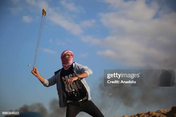 Protesters use slingshot to throw stone to Israeli security forces during a protest against the US President Donald Trumps recognition of Jerusalem...