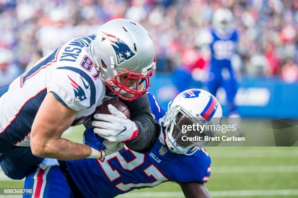 Rob Gronkowski of the New England Patriots makes a reception out of the hands of Tre'Davious White of the Buffalo Bills at New Era Field on December...
