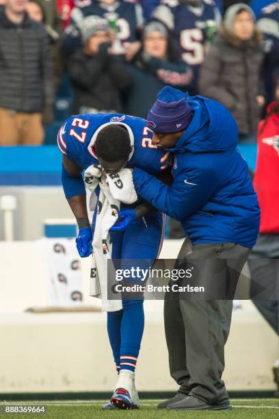 Tre'Davious White of the Buffalo Bills is seen to by a trainer after being hit late by Rob Gronkowski of the New England Patriots following an...