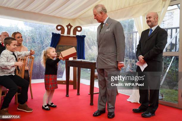 Three-year-old Lexi-Mai, presents the Prince Charles, Prince of Wales a box of handmade cards, made by residents of the Abbeyfield supported housing...