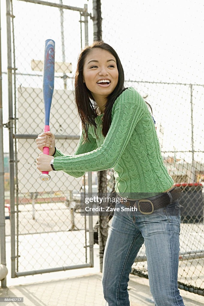 Smiling woman in batting cage
