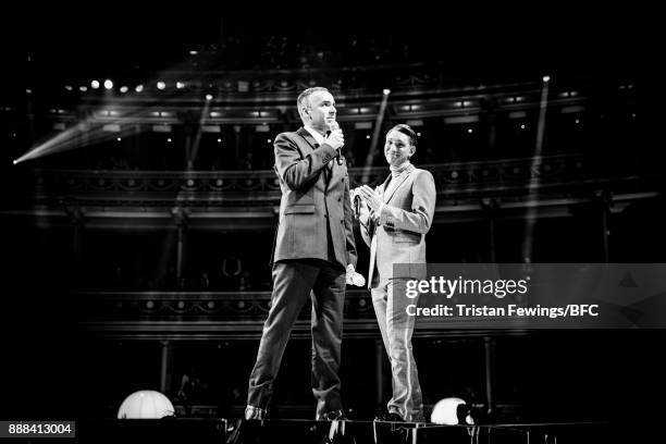 Oliver Sim presents Raf Simons with his award on stage during The Fashion Awards 2017 in partnership with Swarovski at Royal Albert Hall on December...