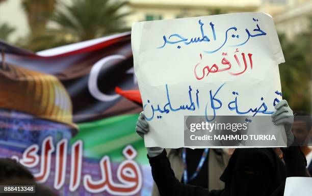 Libyan demonstrator holds a banner reading in Arabic: "Liberating the Al-Aqsa mosque is the cause of all Muslims" during a protest denouncing US...