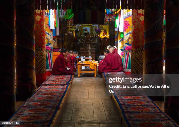 Monks praying and meditating inside Longwu monastery, Tongren County, Longwu, China on October 27, 2017 in Longwu, China.