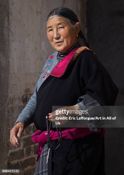 Pilgrim tibetan woman walking the kora around Rongwo monastery, Tongren County, Longwu, China on October 27, 2017 in Longwu, China.