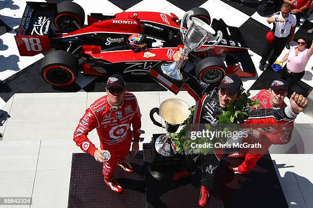 Justin Wilson, driver of the Z-Line Designs Dale Coyne Racing Dallara Honda holds aloft the trophy with third place Scott Dixon and second place Ryan...