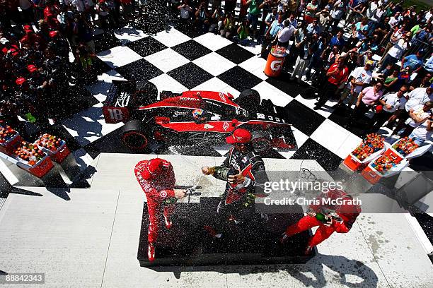 Justin Wilson, driver of the Z-Line Designs Dale Coyne Racing Dallara Honda sprays champagne over third place Scott Dixon and second place Ryan...