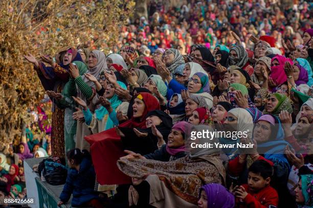 Kashmiri Muslim devotees look towards a cleric displaying the holy relic believed to be the whisker from the beard of the Prophet Mohammed, at...
