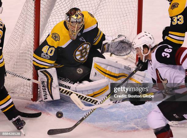 Boston Bruins' goalie Tuukka Rask keeps the net blocked as Coyotes' Christian Fischer swipes at the bouncing puck in the first period. The Boston...