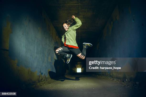 teenage girl jumping in a tunnel - harpazo hope stock pictures, royalty-free photos & images