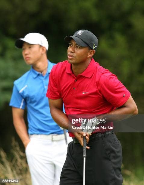 Tiger Woods watches his tee shot on the sixth hole as Anthony Kim looks on during the final round of the AT&T National hosted by Tiger Woods at...